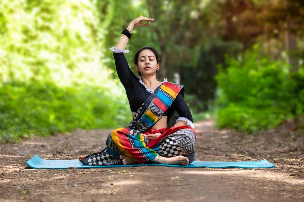 Woman practicing yoga outdoors in Bengaluru, embracing traditional poses and inner peace in lush surroundings.